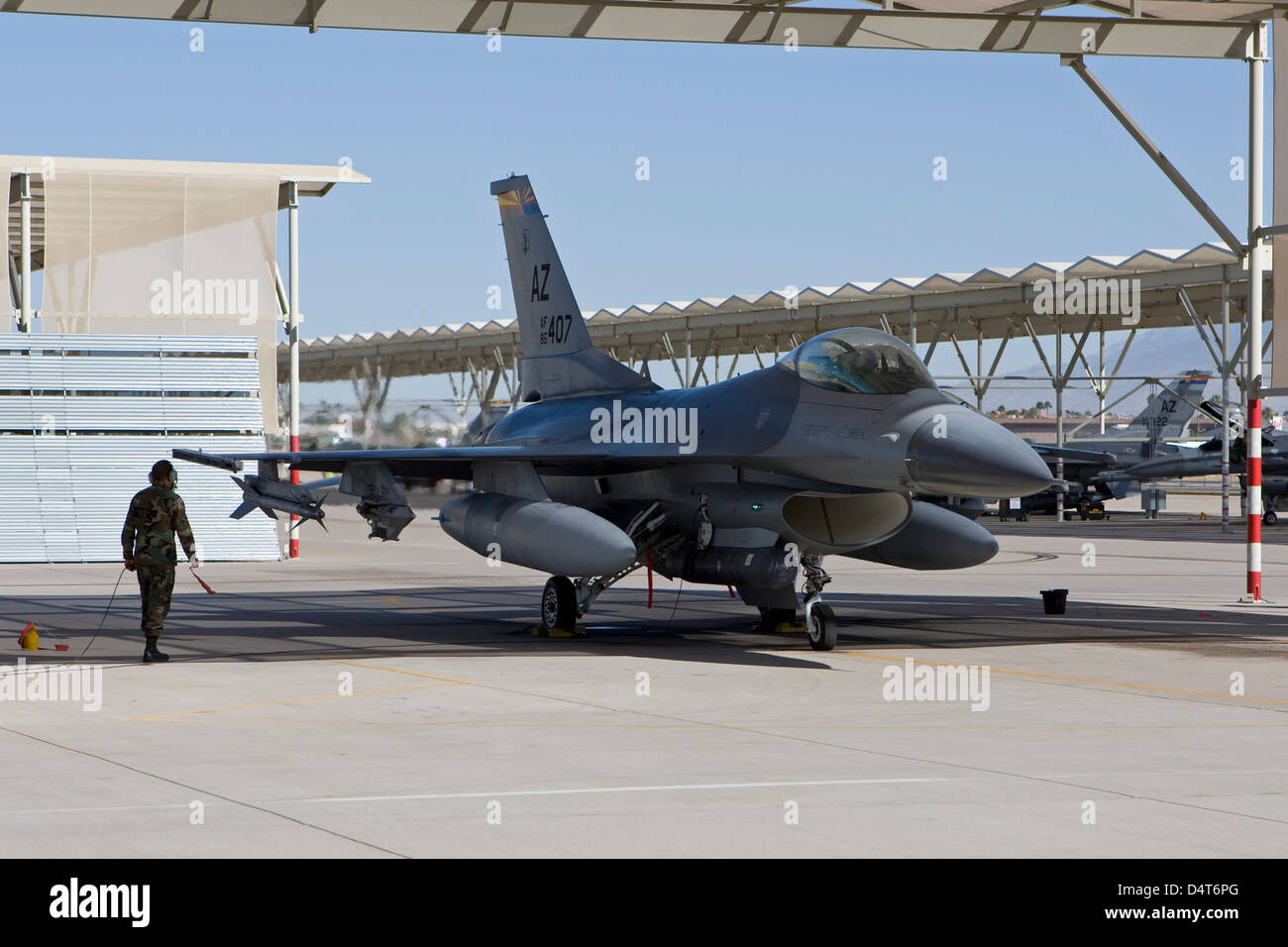 A pilot conducts preflight checks on his F-16 Fighting Falcon. Stock Photo