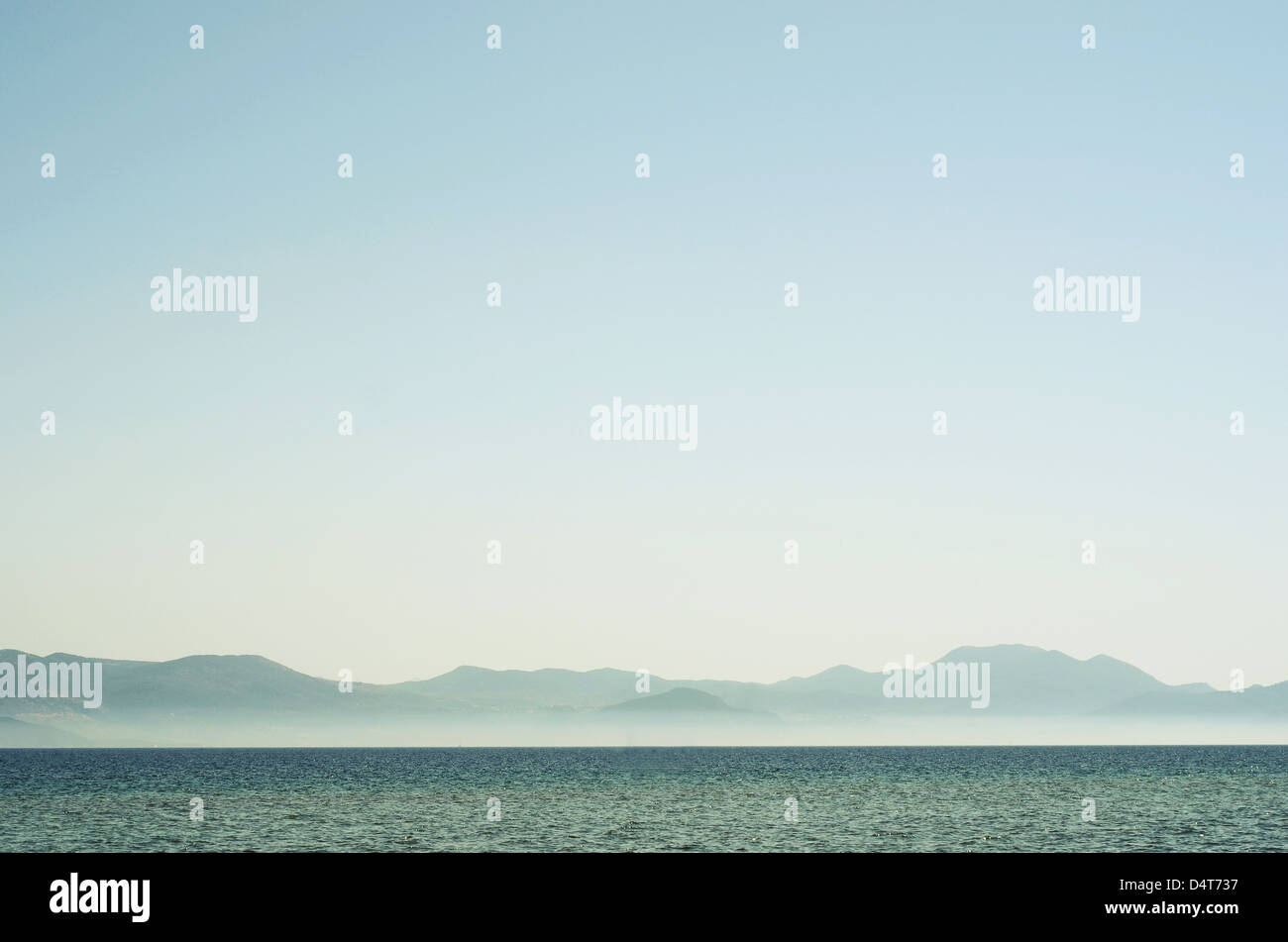 A minimal seascape with mountains in the background. Stock Photo