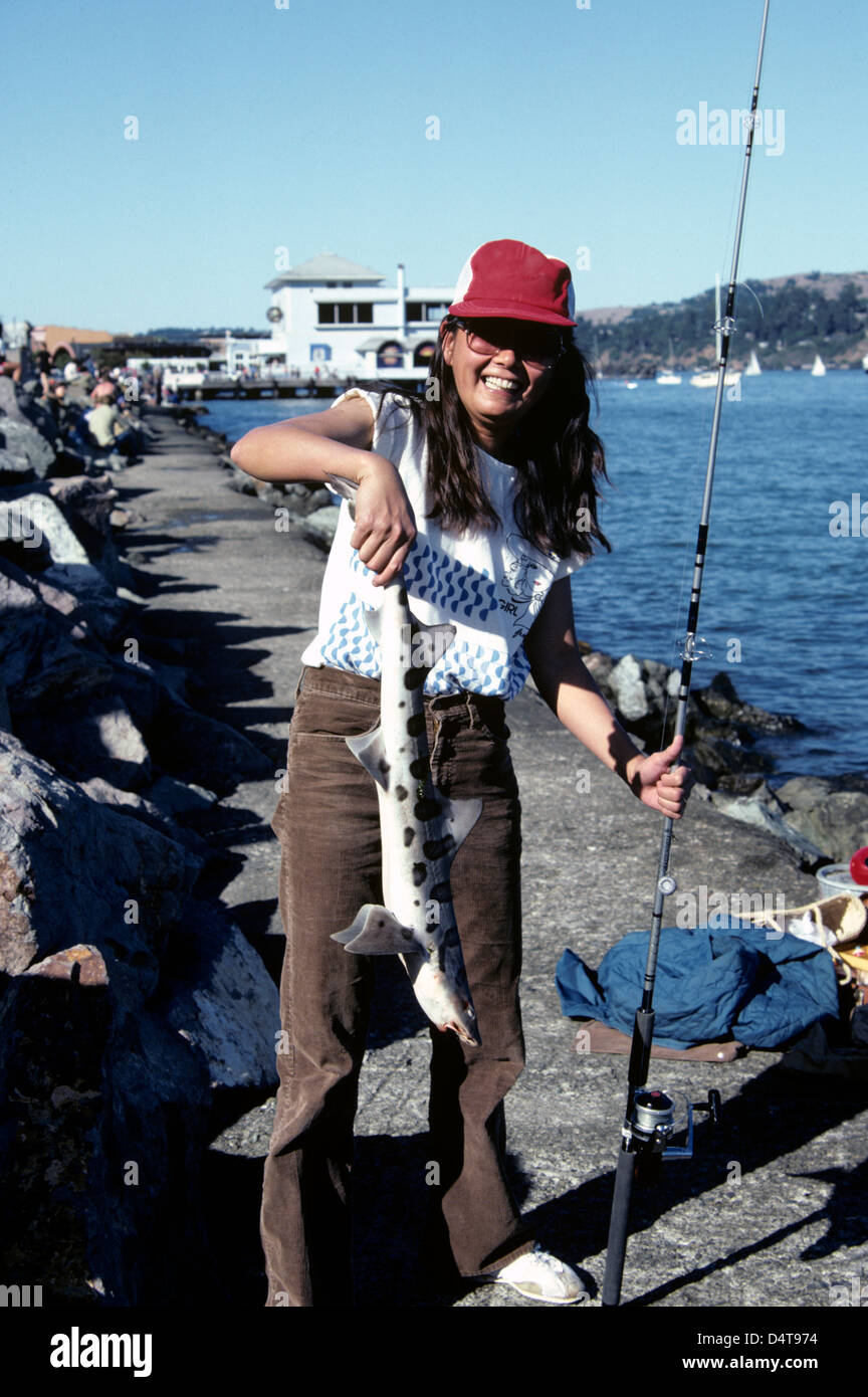 woman poses for camera with leopard shark caught in Sausalito Stock Photo