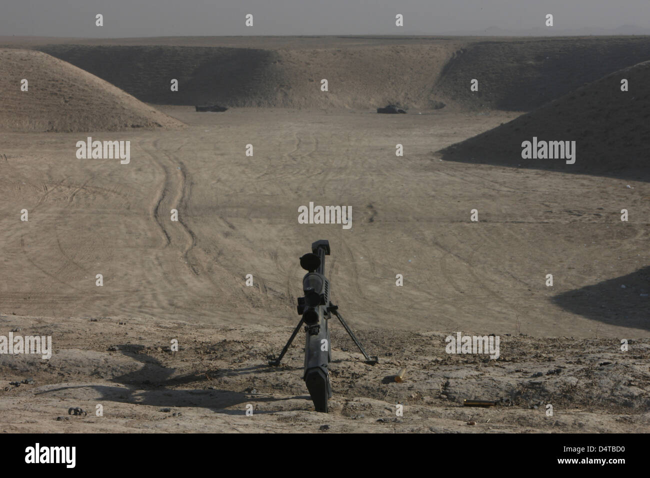 The Barrett M82A1 sniper rifle and spent cartridges on top of a wadi in Northern Afghanistan. Stock Photo