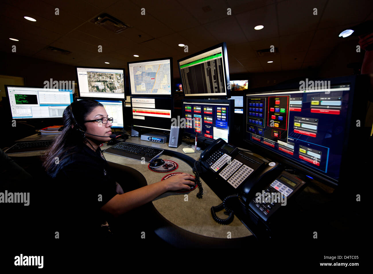 Young woman working in the control room center for emergency service dispatch. Stock Photo