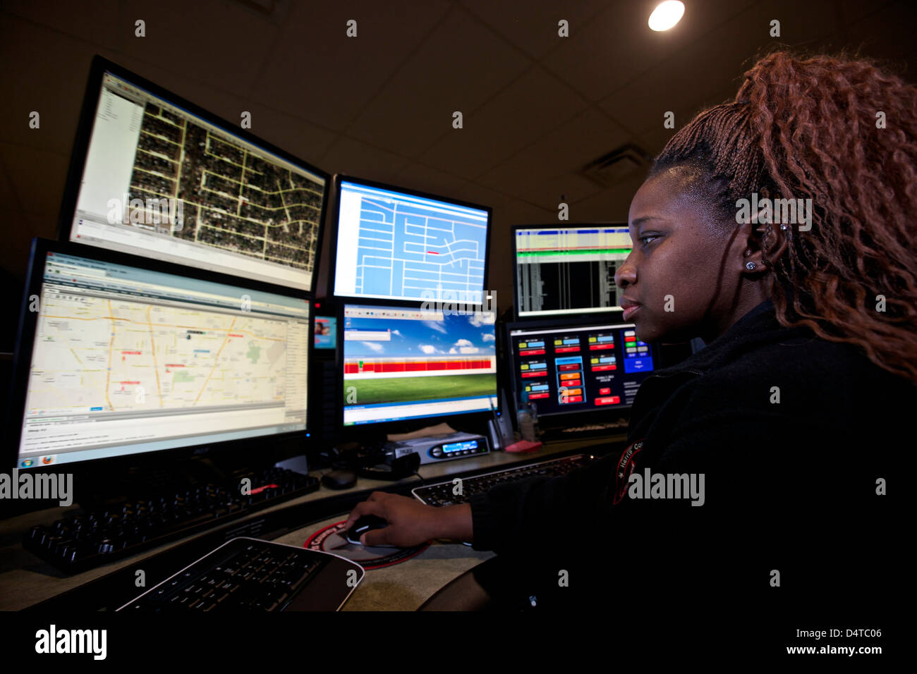 Young woman working in the control room center for emergency service dispatch. Stock Photo