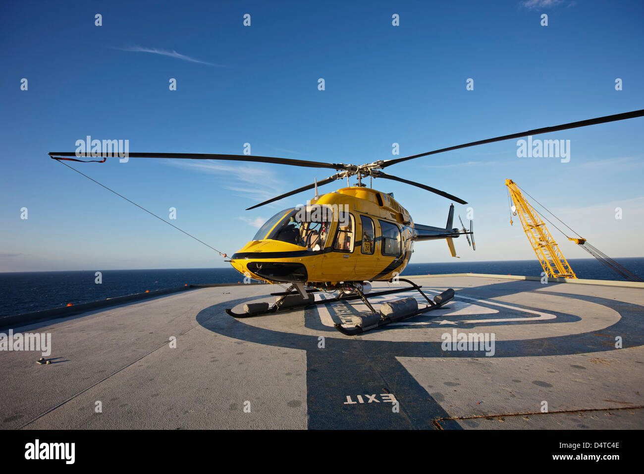 A Bell 407 utility helicopter on the helipad of an oil rig. Stock Photo