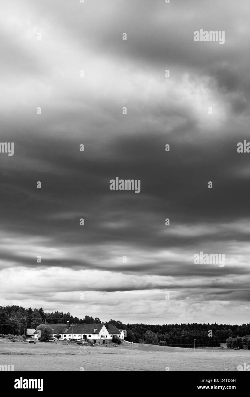Stormy, ominous sky with a farm house in the background Stock Photo