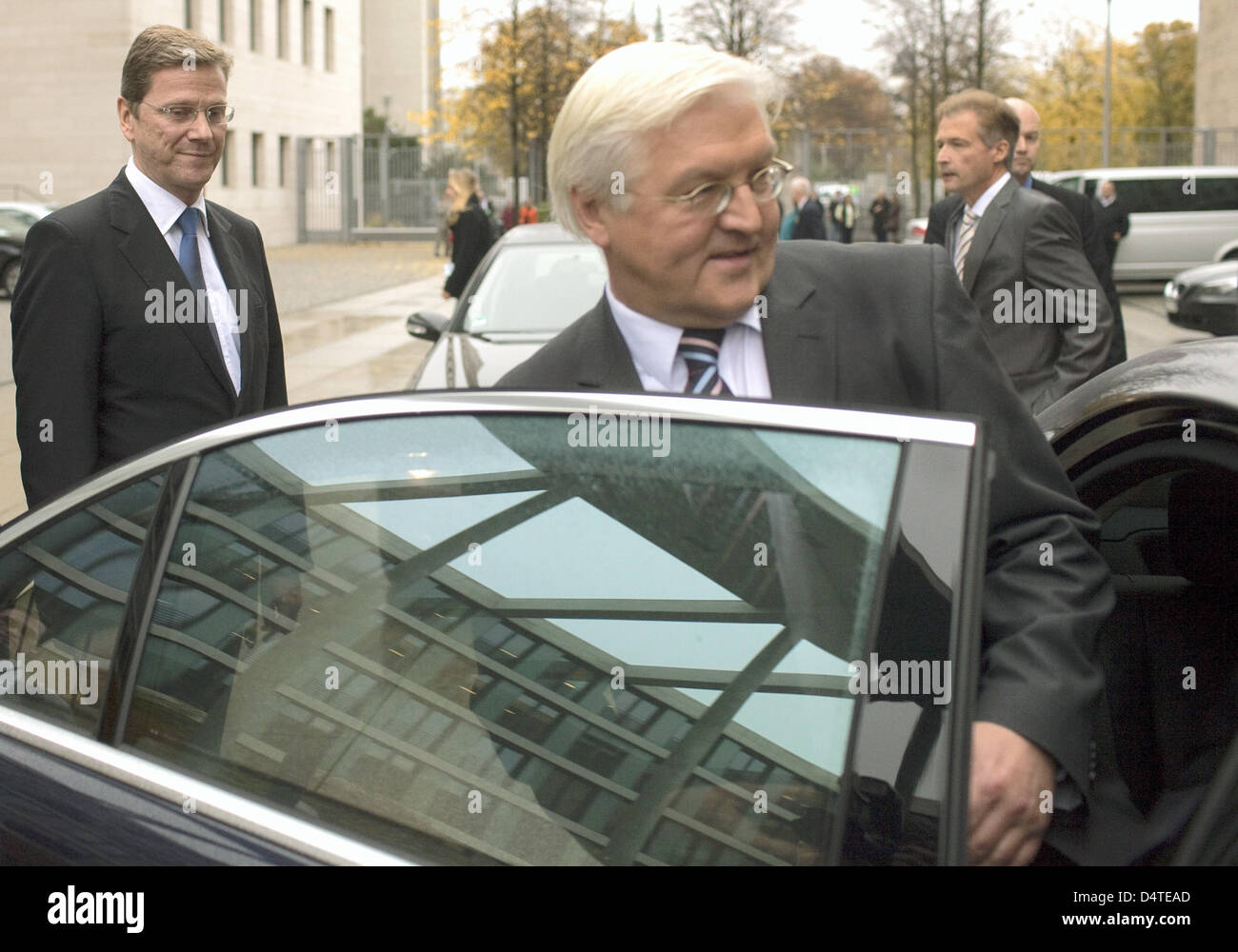 German Foreign Minister Guido Westerwelle (Liberal Democrats, L) watches former German Foreign Minister and Vice Chancellor Frank-Walter Steinmeier (Social Democrats) get into his car in front of the Ministry of Foreign Affairs in Berlin, Germany, 29 October 2009. Photo: ARNO BURGI Stock Photo