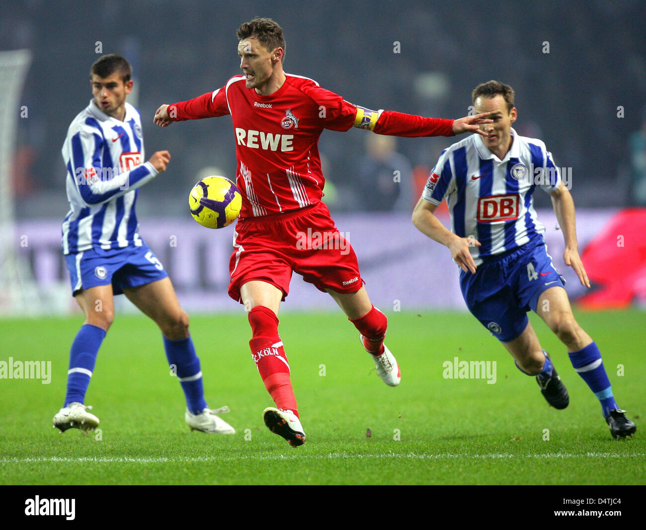 Berlin?s Steve von Bergen (R) and Nemanja Pejcinovic (L) fight for the ball with Cologne?s Milivoje Novakovic during the German Bundesliga match Hertha BSC Berlin vs 1. FC Cologne at Olympic Stadium in Berlin, Germany, 08 November 2009. Photo: JENS WOLF (ATTENTION: BLOCKING PERIOD! The DFL permits the further utilisation of the pictures in IPTV, mobile services and other new techno Stock Photo