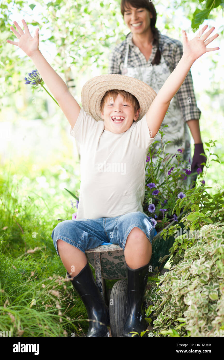 Boy sitting in wheelbarrow of plants Stock Photo - Alamy
