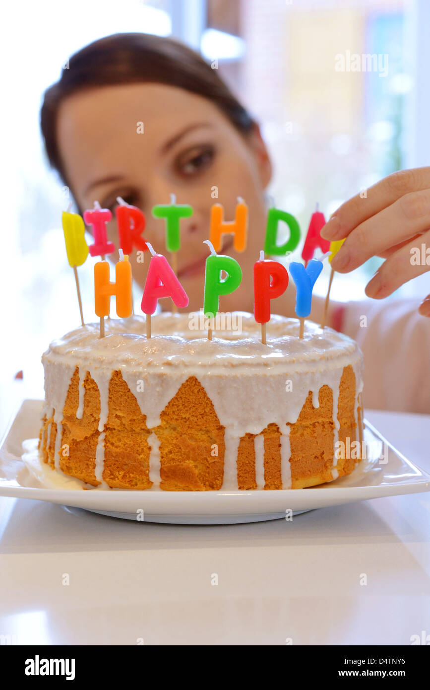 A young woman decorates a birthday cake with candles Stock Photo - Alamy