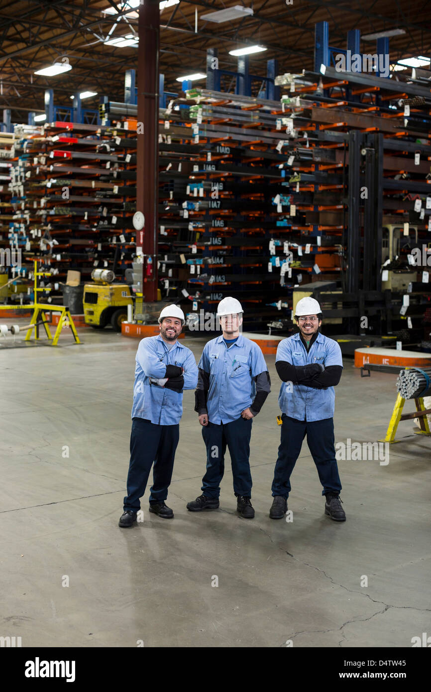 Workers standing in metal plant Stock Photo