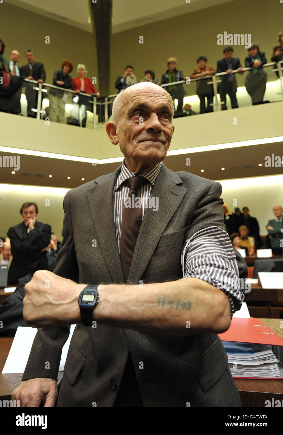 Survivor of the Auschwitz-Birkenau concentration camp and joint plaintiff Robert Cohen shows his concentration camp identification tattoo prior to the trial against alleged Nazi war criminal John Demjanjuk at the District Court in Munich, Germany, 30 November 2009. Cohen lost relatives at Sobibor concentration camp. One of the last nazi trials opens on 30 November 2009. 89-year-old Stock Photo