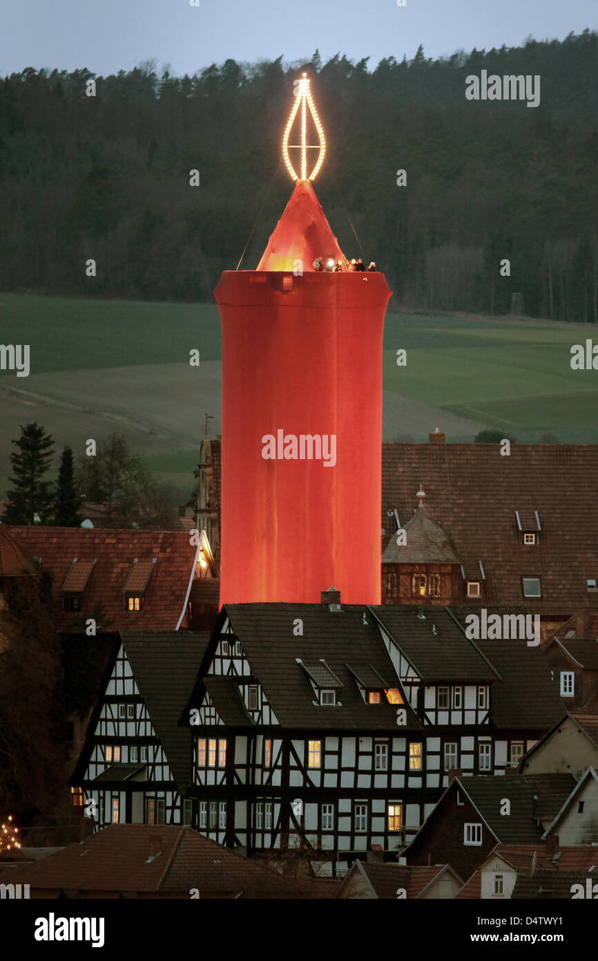 A steeple is covered with red cloth to form the world's largest candle at  the Christmas market in Schlitz, Germany, 29 November 2009. The candle is  made of a stone tower which