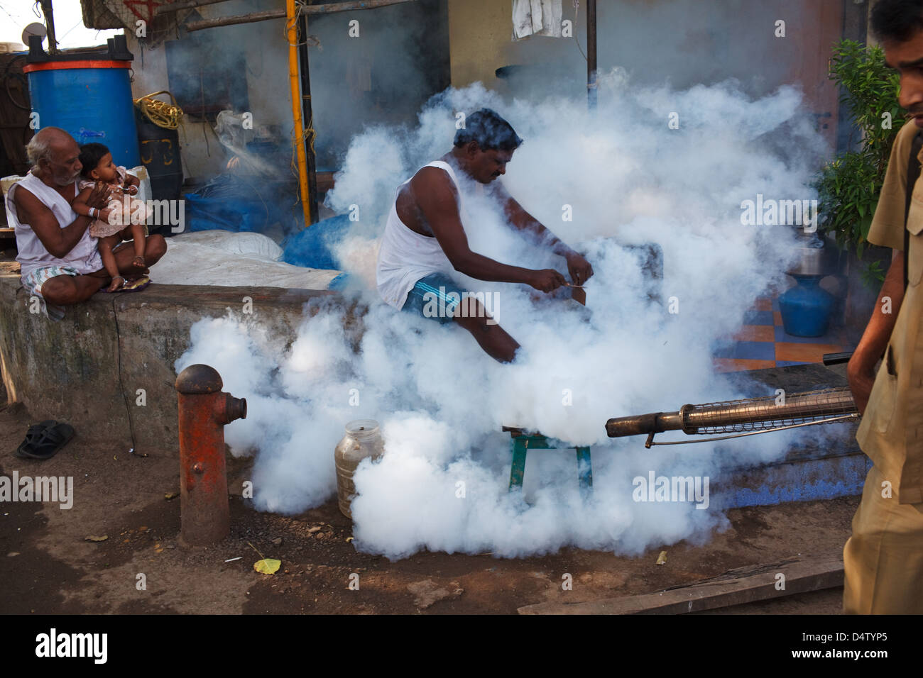 Anti-dengue fumigating to kill mosquitoes spreading malaria and dengue fever in a slum in Colaba, Mumbai, India. Stock Photo