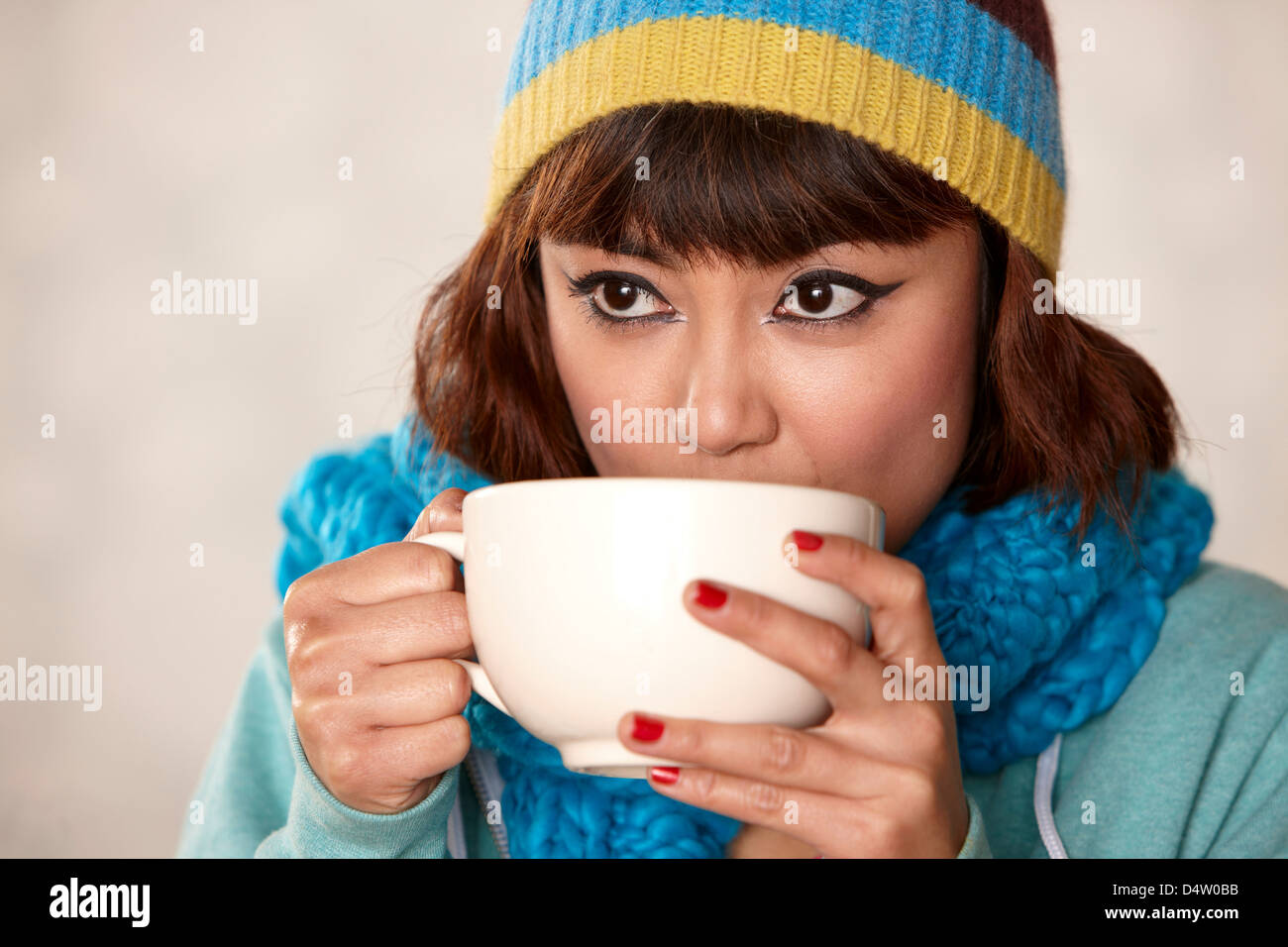 Woman in scarf drinking cup of coffee Stock Photo