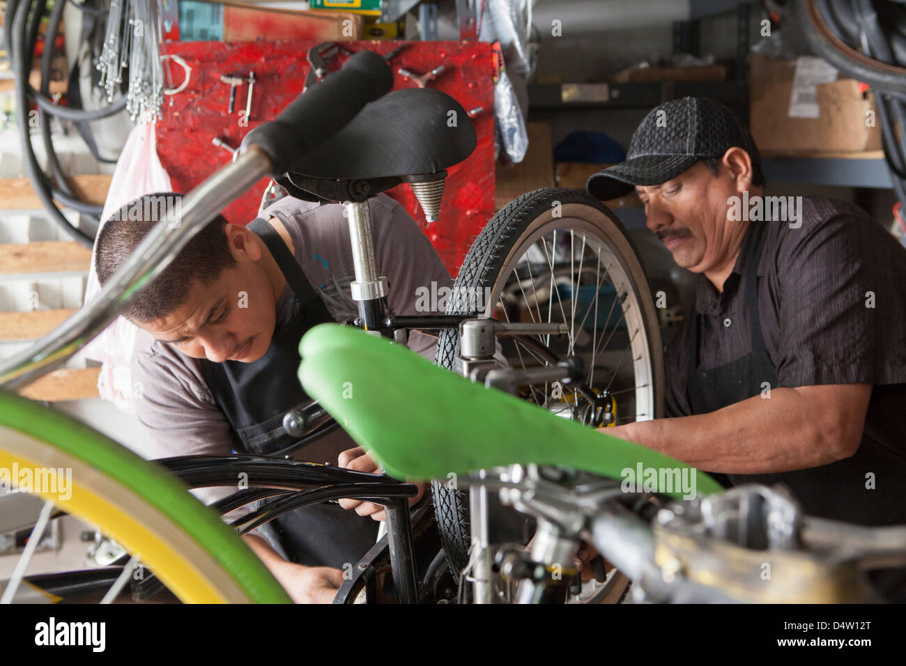 Mechanics working in bicycle shop Stock Photo