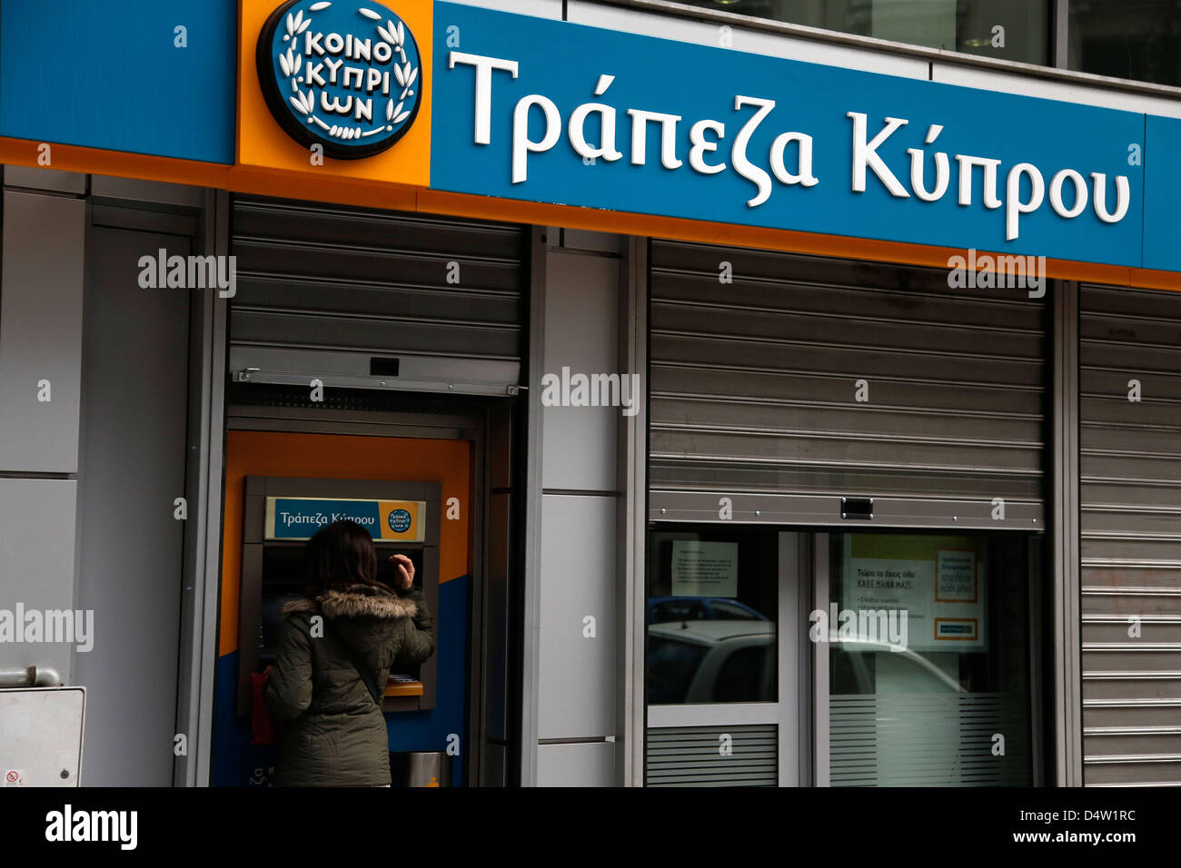Thessaloniki, Greece. March 19, 2013. Bank customers make transactions at an automated teller