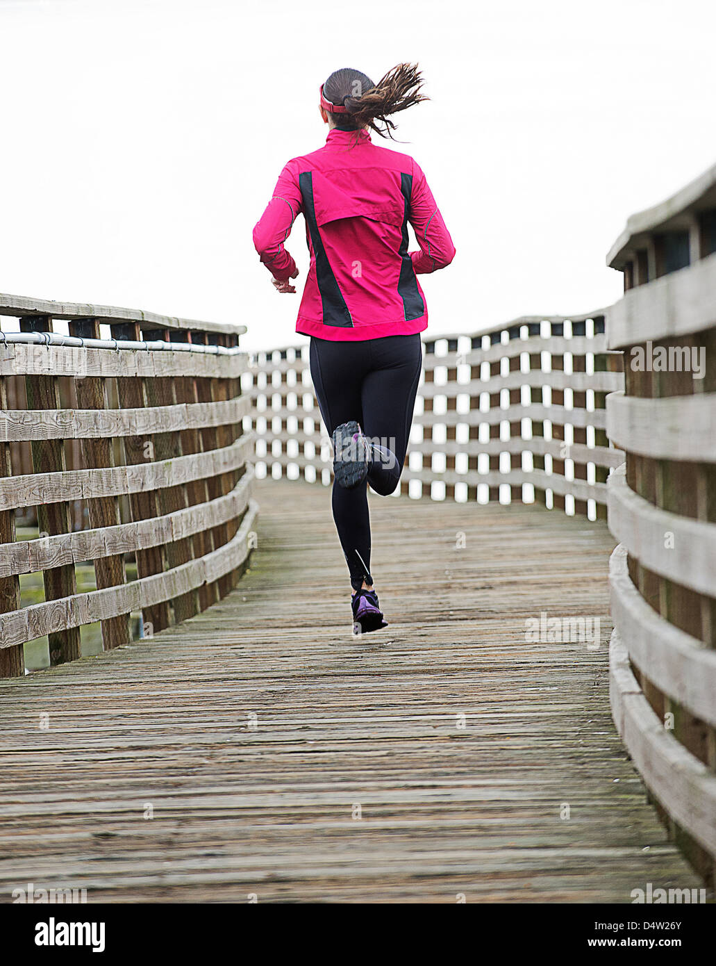 Woman running on wooden dock Stock Photo