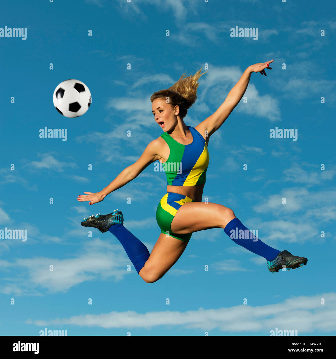 Soccer player kicking in mid-air Stock Photo