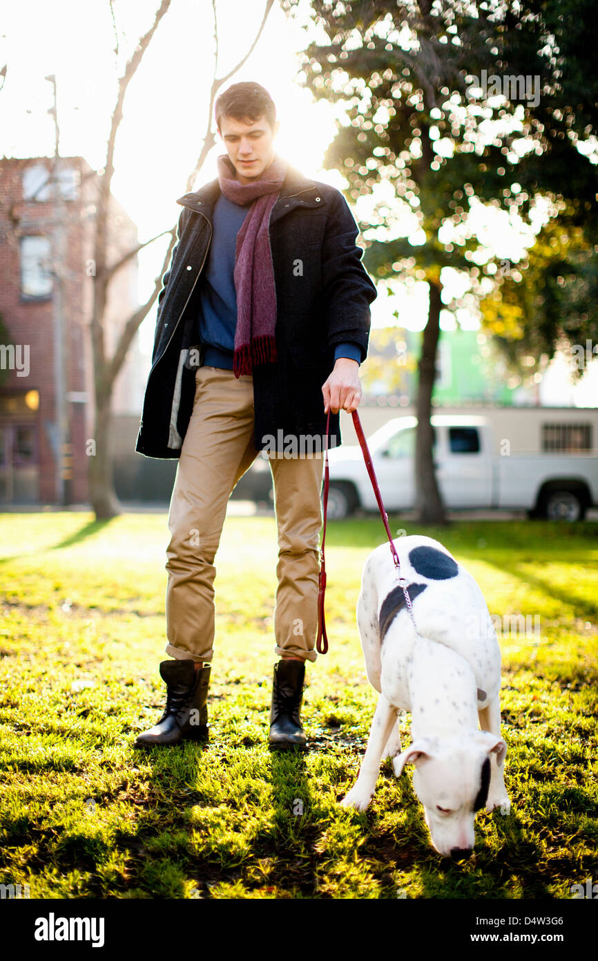 Man walking dog in park Stock Photo