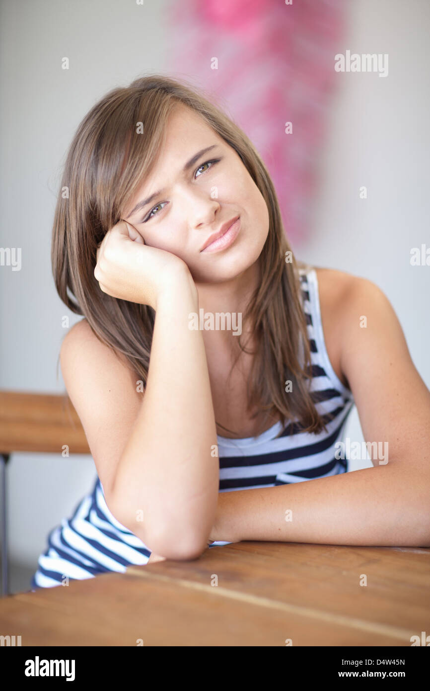 Teenage girl resting cheek on hand Stock Photo Alamy