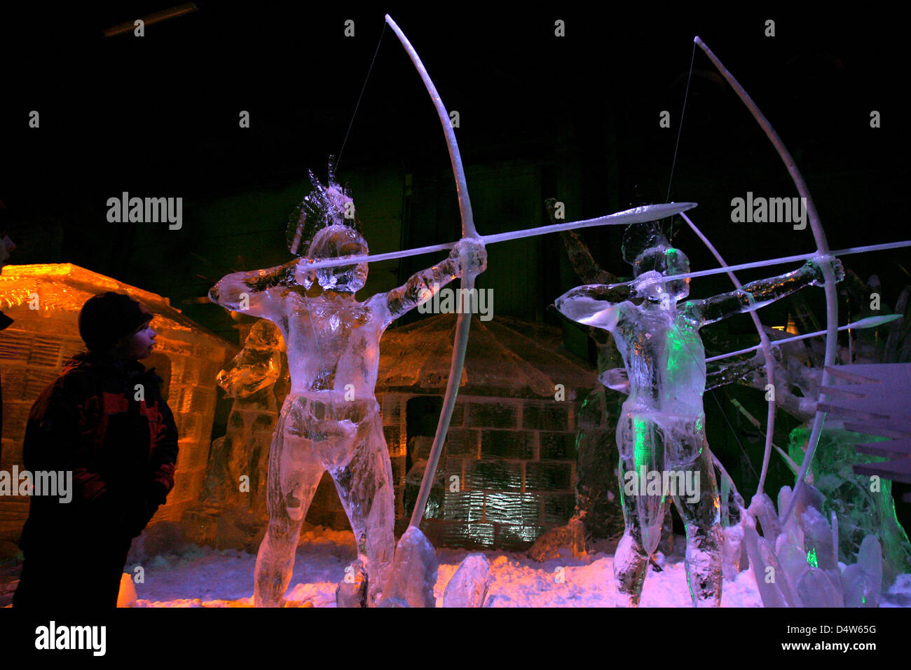 A boy looks at bowmen made out of ice during a press appointment in a cold storage house in 'Karls Erlebnis-Dorf' in Roevershagen near Rostock, Germany, 22 December 2009. The figures are part of the '7. Eiszeit' dealing with the topic 'Welcome to the Jungle', which will open 25 December 2009. In a four-week work, 15 artists design a 2,000 square metre large ice and snow landsacpe.  Stock Photo