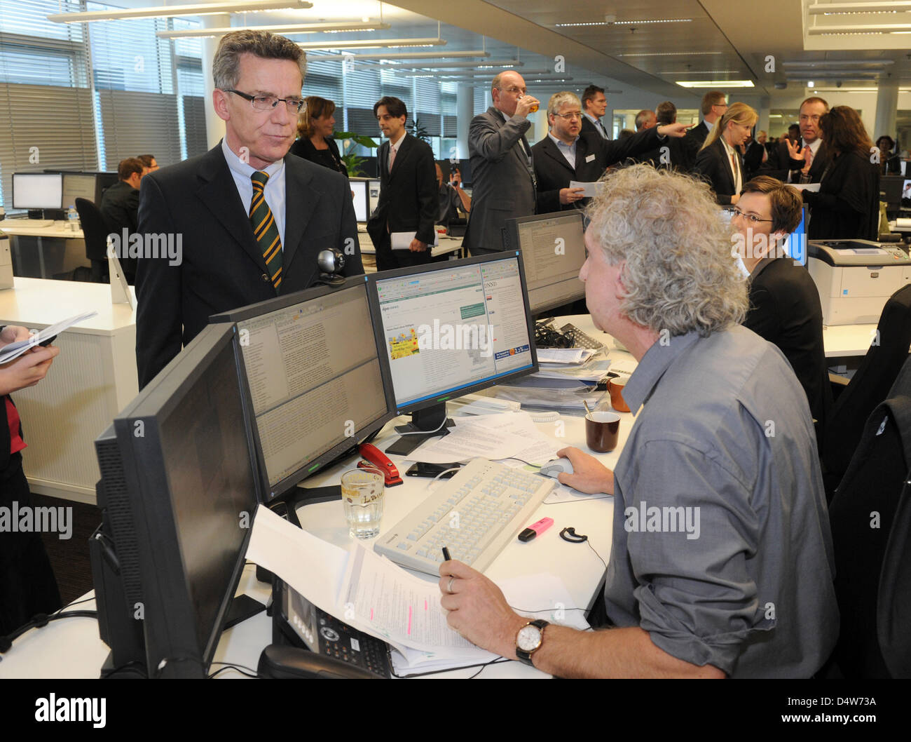 German Interior Minister Thomas de Maiziere (CDU-L) talks to editor in charge Froben Homburger in the new central editorial department of the German Press Agency dpa in Berlin, Germany, 15 September 2010. For the first time in the history of the dpa, the largest German press agency has brought together its central editorial departments into one newsroom. More than two dozen editori Stock Photo