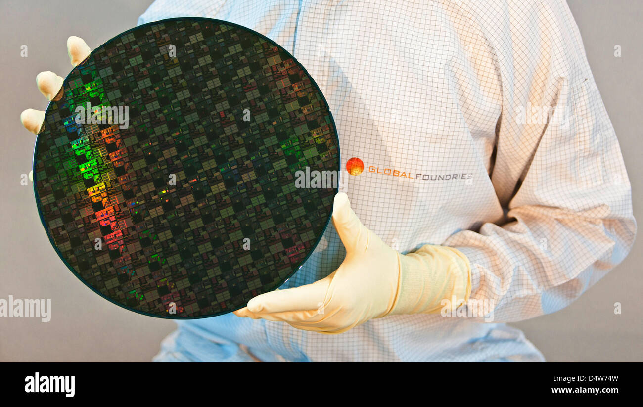 An employee holds a 300mm large chip wafer in his hands, while the foundation of 'Fab 1 Annex' is layed at the site of chip manufacturer 'Globalfoundries' in Dresden, Germany, 15 September 2010. For 1,2 billion euro, Globalfoundries intends to expand its plant in Dresden. On the so-called 'Fab 1'- area the founding stone was layed for a 10 000 sq.m large cleanroom. Globalfoundries  Stock Photo