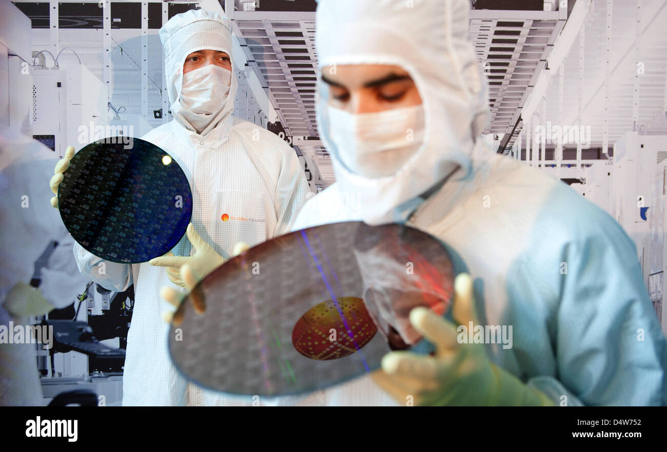 Employees hold 300mm large chip wafers in their hands, while the foundation of 'Fab 1 Annex' is layed at the site of chip manufacturer 'Globalfoundries' in Dresden, Germany, 15 September 2010. For 1,2 billion euro, Globalfoundries intends to expand its plant in Dresden. The founding stone was layed for a 10 000 sq.m large cleanroom on the area 'Fab 1'. Globalfoundries wishes to inc Stock Photo