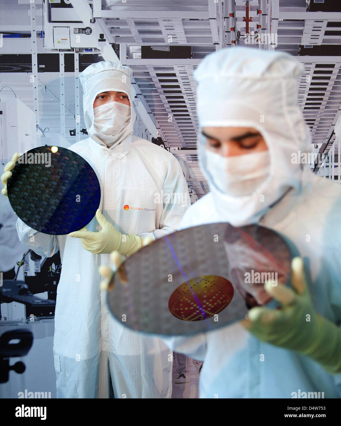 Employees hold 300mm large chip wafers in their hands, while the foundation of 'Fab 1 Annex' is layed at the site of chip manufacturer 'Globalfoundries' in Dresden, Germany, 15 September 2010. For 1,2 billion euro, Globalfoundries intends to expand its plant in Dresden. The founding stone was layed for a 10 000 sq.m large cleanroom on the area 'Fab 1'. Globalfoundries wishes to inc Stock Photo