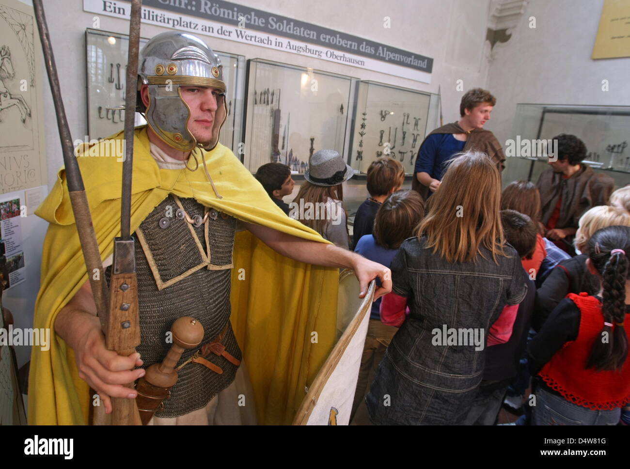 A man dressed-up as Roman soldier leads pupils through an exhibition at Roman Museum in Augsburg, Germany, 17 September 2010. Photo: Karl-Josef Hildenbrand Stock Photo