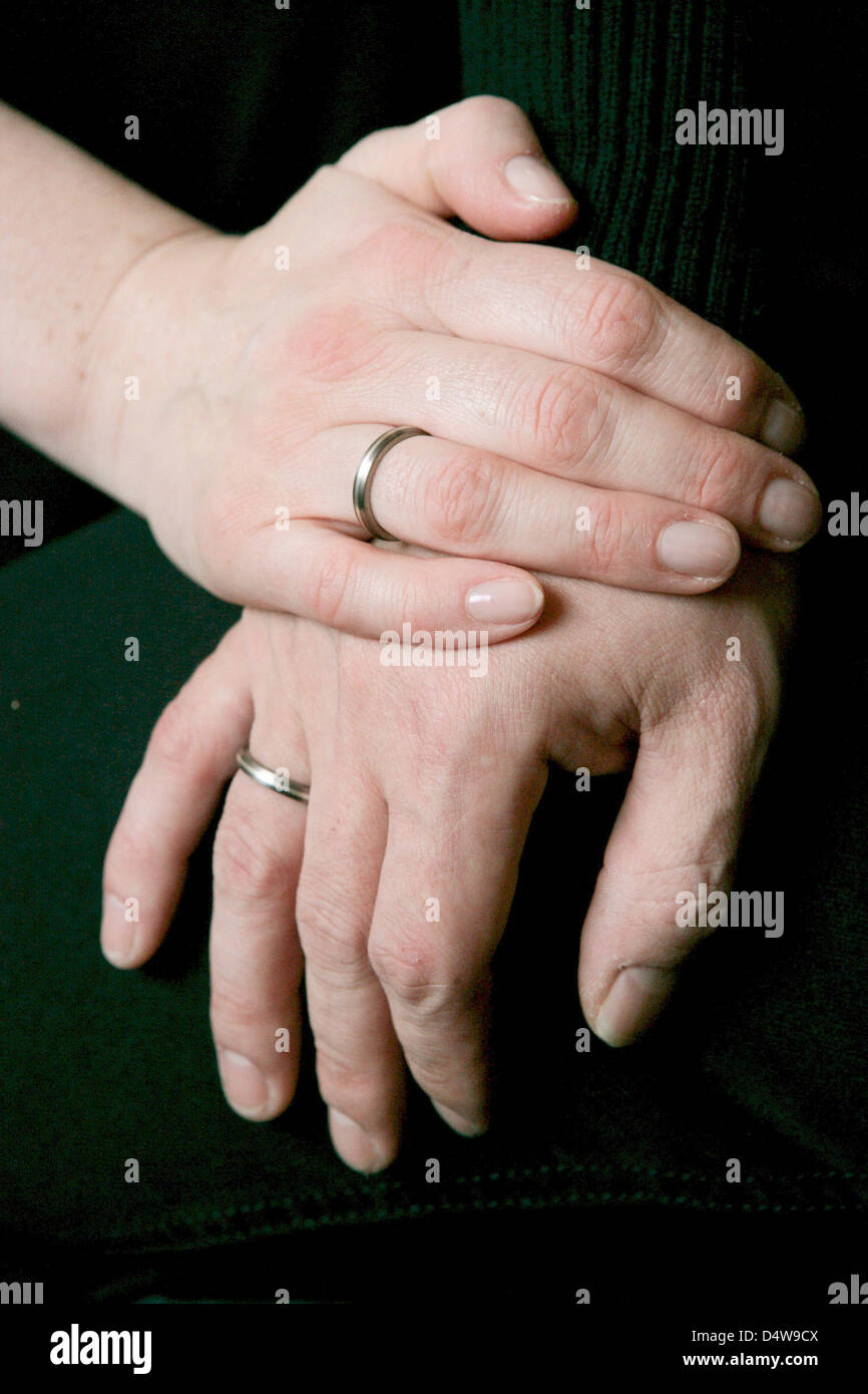 A couple's hands with wedding rings touch at the register office in  Leipzig, Germany, 10 September 2010. Weddings on special dates like  10/10/10 or 10/20/10 are not as popular anymore, according to