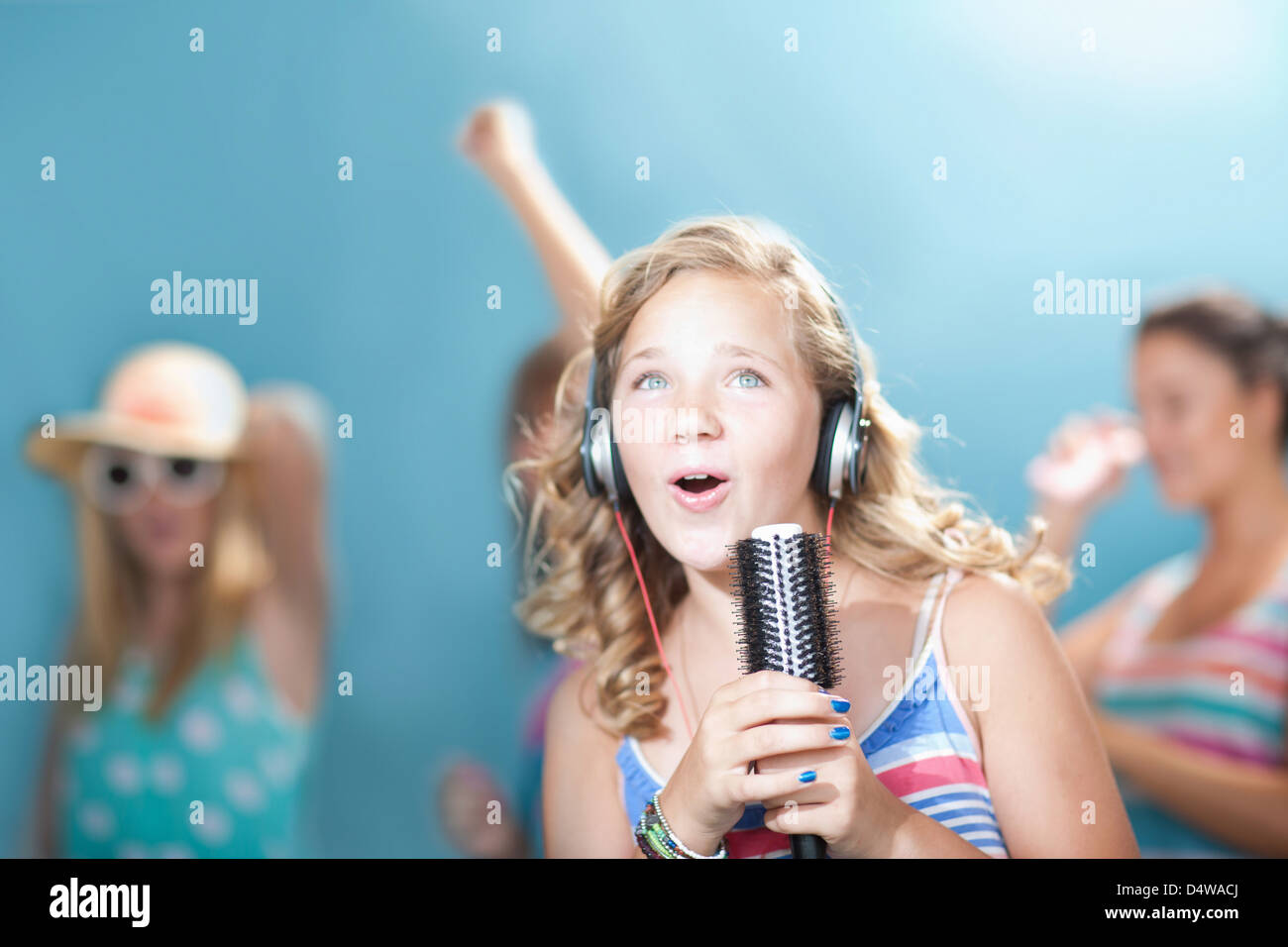 Girl singing into hairbrush Stock Photo