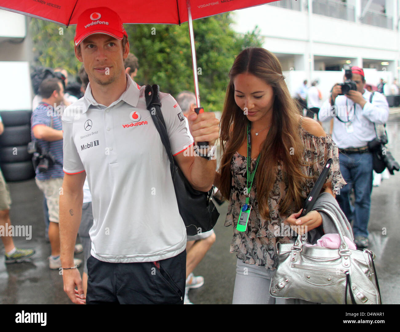 British Formula One driver Jenson Button of McLaren Mercedes and his girlfriend Jessica Michibata walk through the paddock in Singapore, 23 September 2010. The Formula One Night Race for the Singapore Grand Prix will take place at the Singapore Harbour race circuit on 26 September 2010. Photo: Jan Woitas Stock Photo