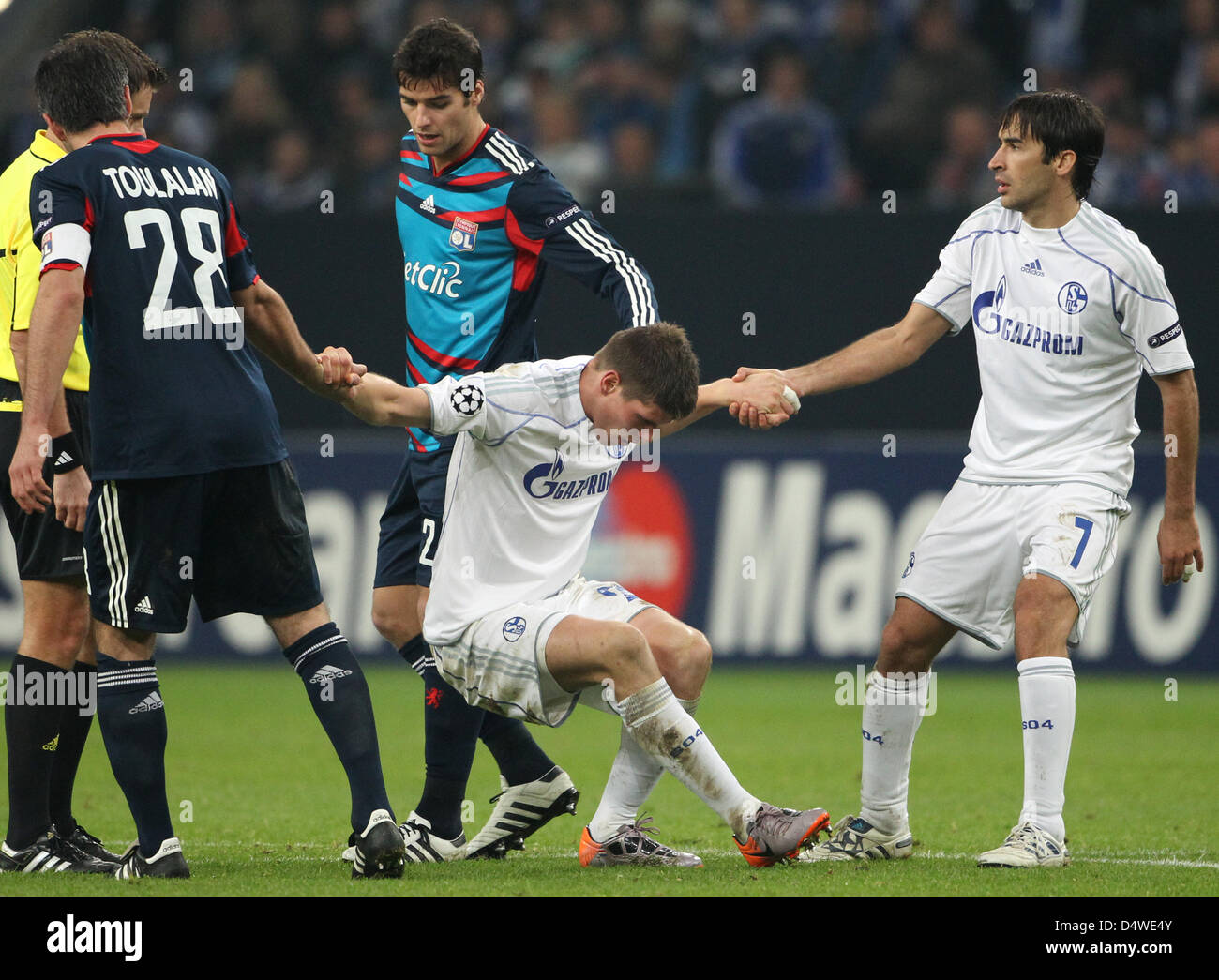 Schalke's Klaas Jan Huntelaar (C) is lifted by Lyon's Jeremy Toulalan (L) and his teammate Raul (R) during their UEFA Champions League group B match FC Schalke 04 vs Olympique Lyon at Veltins-Arena stadium in Gelsenkirchen, Germany, 24 November 2010. Photo: Friso Gentsch Stock Photo