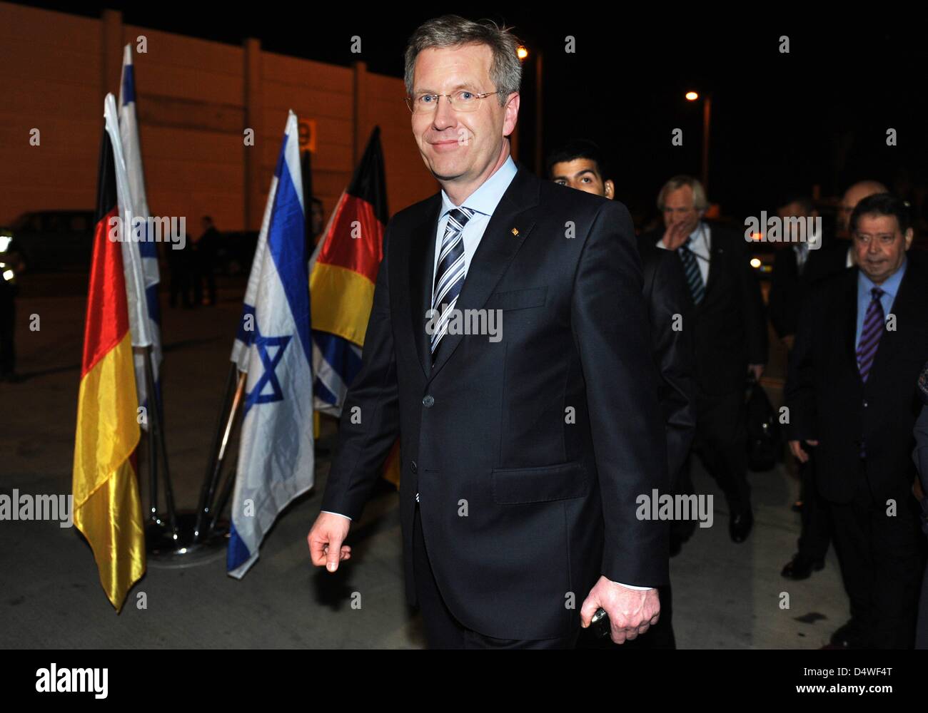 German President Christian Wulff walks past German and Israeli flags after arriving with daughter Annalena in Tel Aviv, Israel, 27 November 2010. Wulff's 17-year-old daughter accompanies Mr Wulff on his four-day visit to Israel in stead of his wife Bettina. The choice of travel companion is supposed to symbolize the importance of transmitting the memory of the Holocaust to younger  Stock Photo