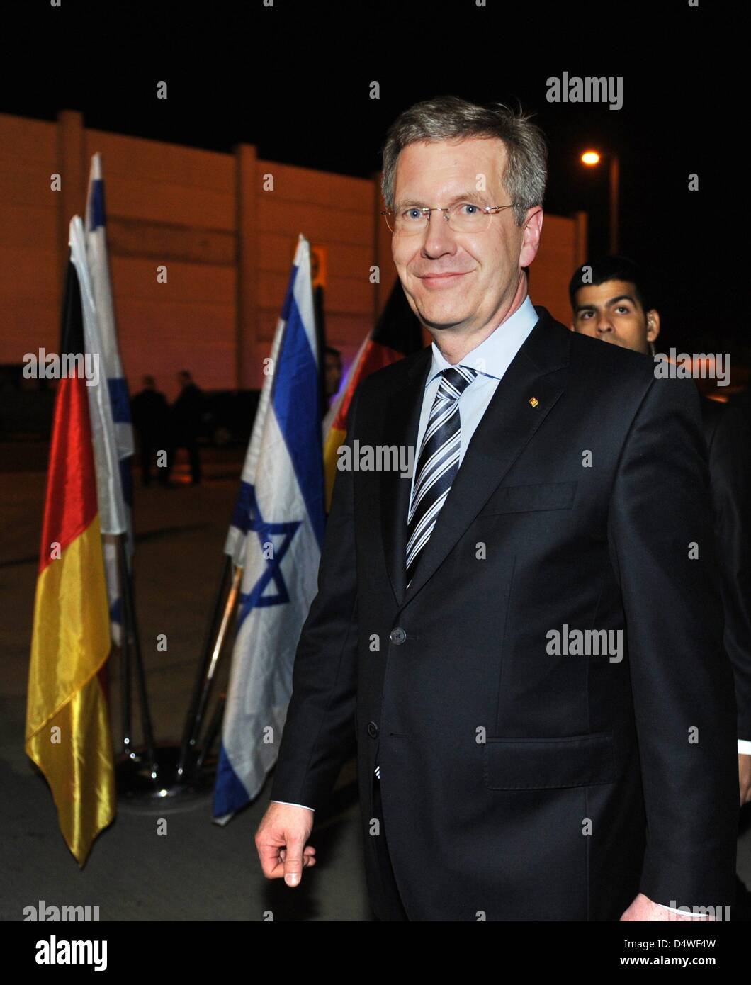 German President Christian Wulff walks past German and Israeli flags after arriving with daughter Annalena in Tel Aviv, Israel, 27 November 2010. Wulff's 17-year-old daughter accompanies Mr Wulff on his four-day visit to Israel in stead of his wife Bettina. The choice of travel companion is supposed to symbolize the importance of transmitting the memory of the Holocaust to younger  Stock Photo