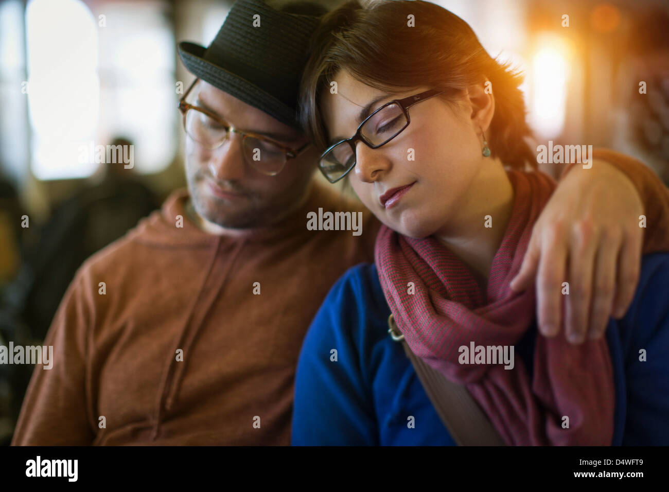Couple napping on bench together Stock Photo