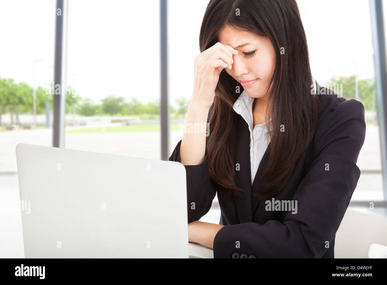 tired young businesswoman with laptop in the office Stock Photo - Alamy