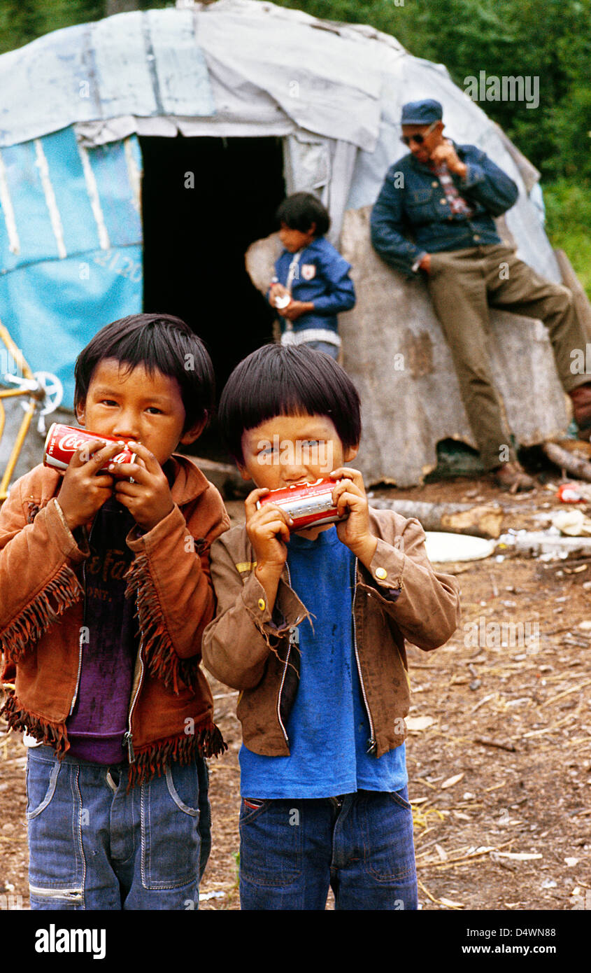 Two First Nation Indian Kids drinking out of a pop can sideways at Moose Factory in Hudson's Bay;Ontario;Canada Stock Photo
