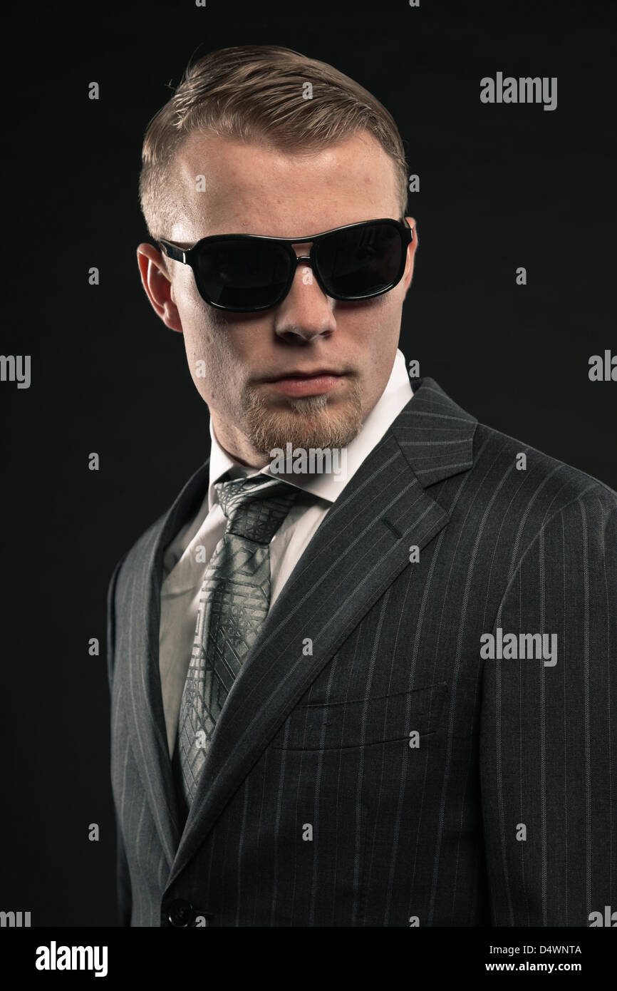 Fashion man in suit wearing sunglasses. Studio shot Stock Photo - Alamy