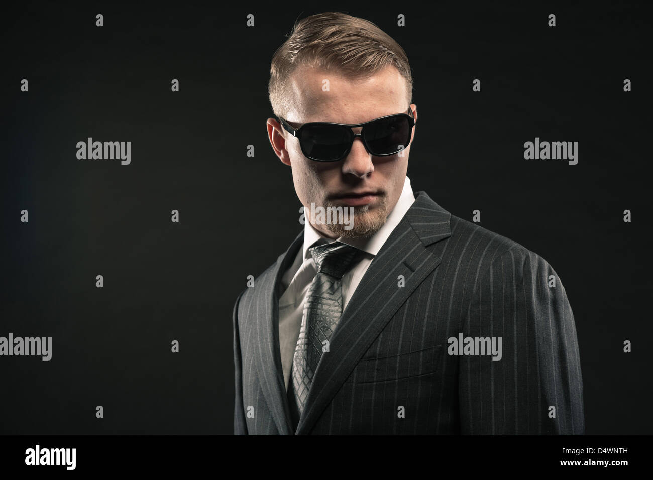 Fashion man in suit wearing sunglasses. Studio shot Stock Photo - Alamy