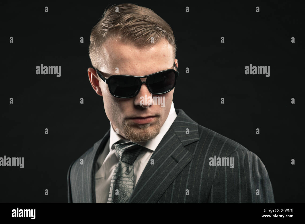 Fashion man in suit wearing sunglasses. Studio shot Stock Photo - Alamy