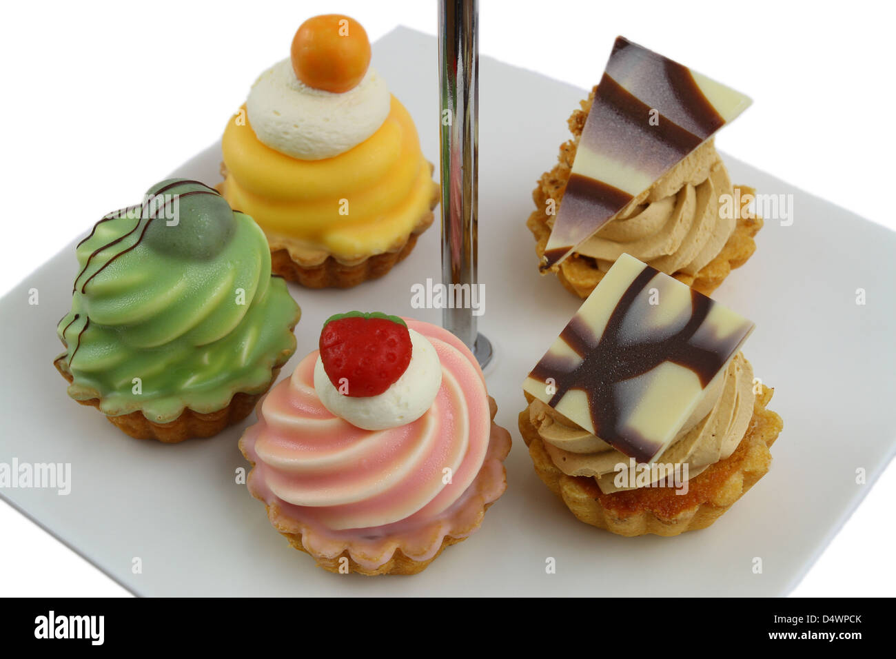 Luxury petit fours on cake tray isolated on white Stock Photo