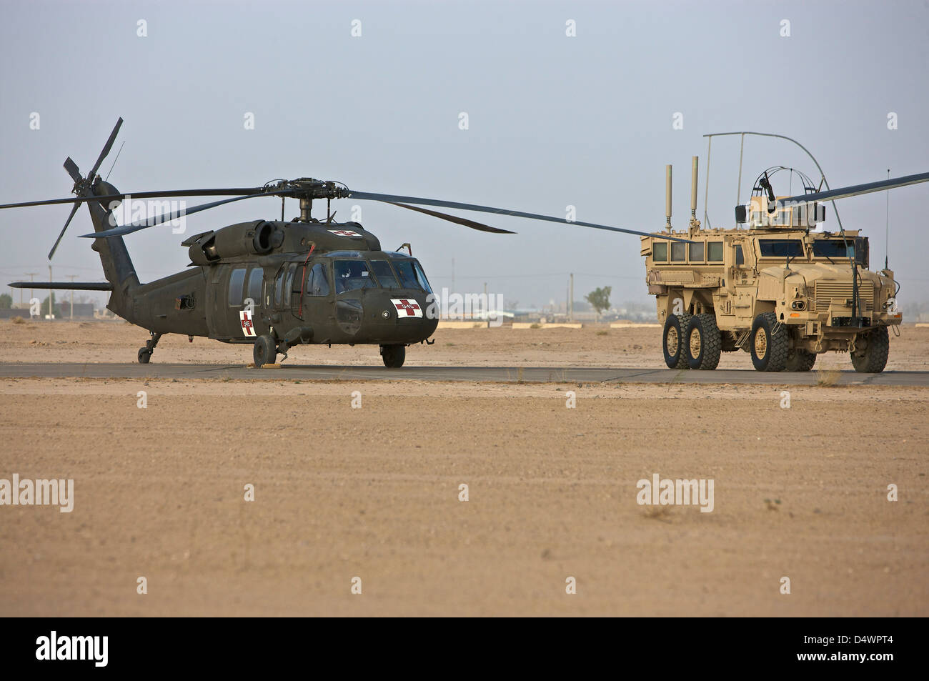 A U.S. Army medevac UH-60 Black Hawk helicopter and a RG-33 MRAP vehicle at COB Speicher, Tikrit, Iraq. Stock Photo