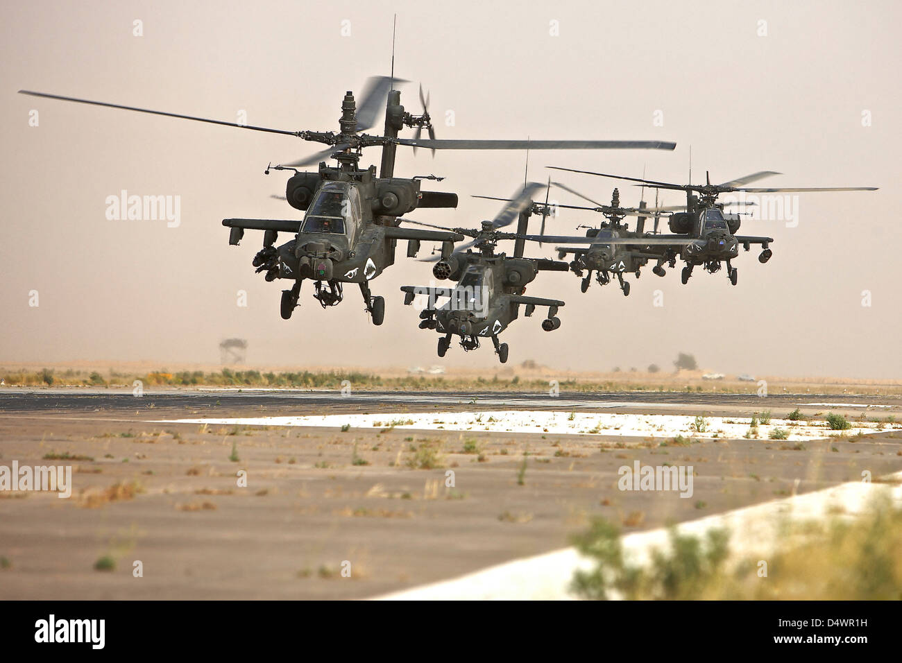 A group of AH-64D Apache helicopters landing on the runway. Stock Photo