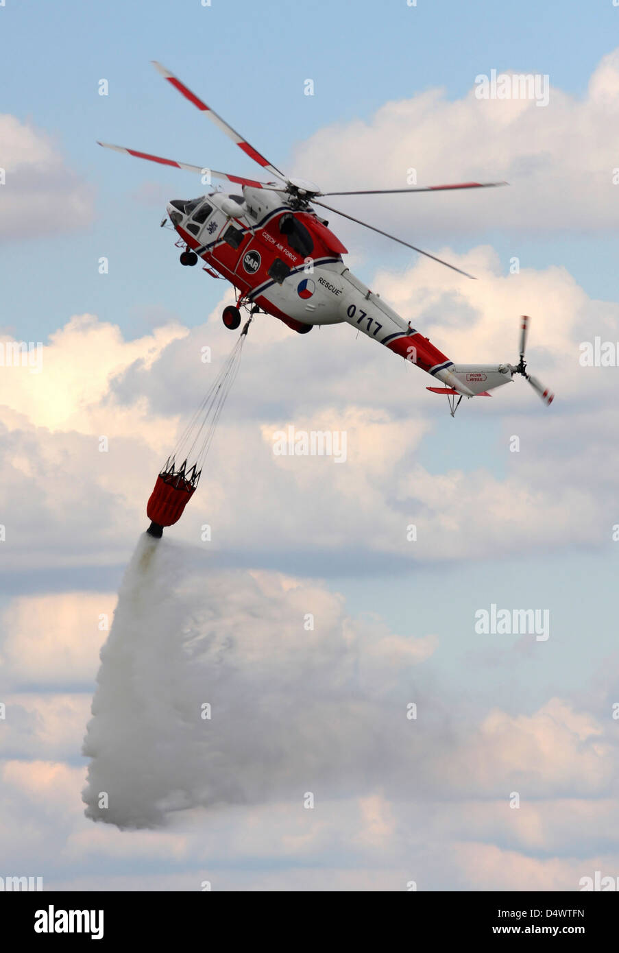 A Sokol W-3A SAR helicopter of the Czech Air Force firefighting with a water bucket over Hradec Kralove, Czech Republic. Stock Photo