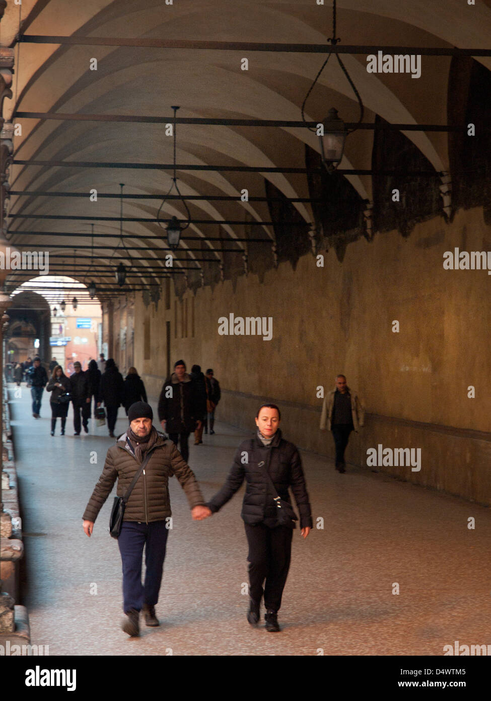 People walking down an arcade in Bologna. Stock Photo