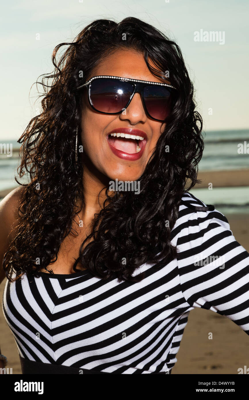 Pretty indian girl with sunglasses on the beach in summer Stock Photo