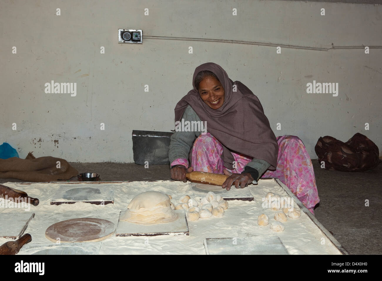 A female volunteer rolling out chapattis at the free kitchen inside the Golden Temple complex Amritsar Punjab India Stock Photo