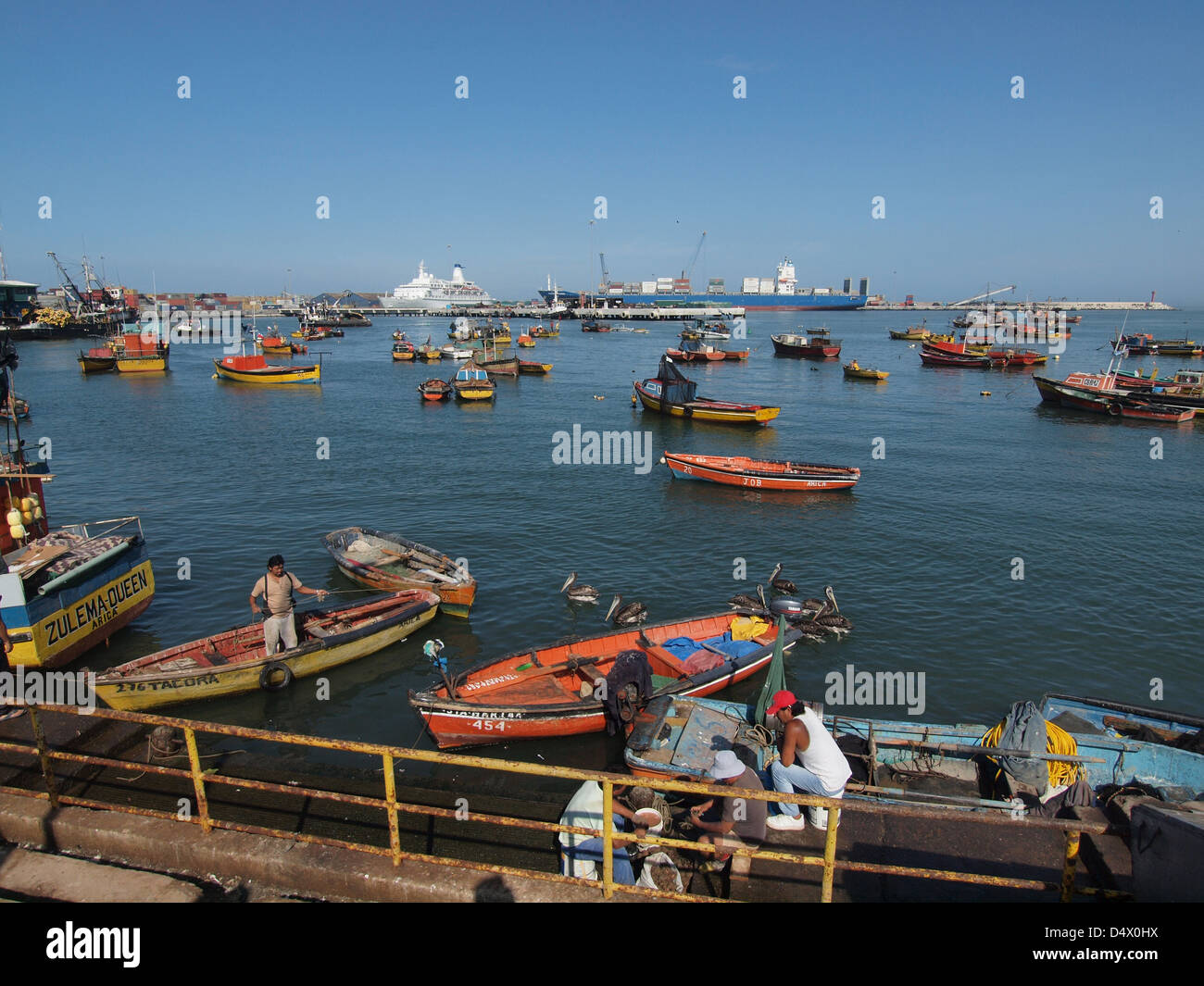Fishing boats in the harbour of Arica in the North of Chile. Cruise ship Discovery in the background Stock Photo