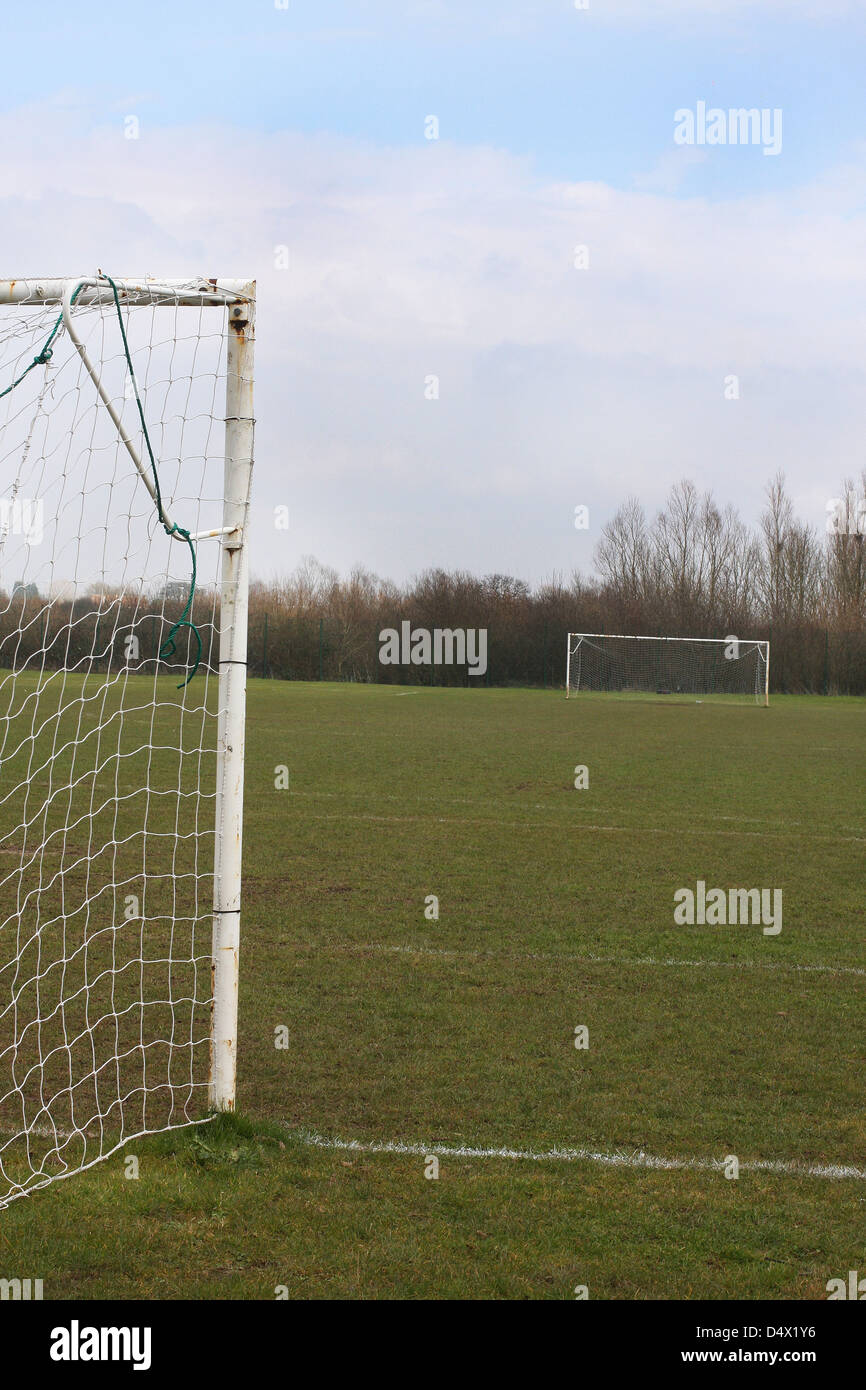 football field with goals, taken from one end. grass is poor following